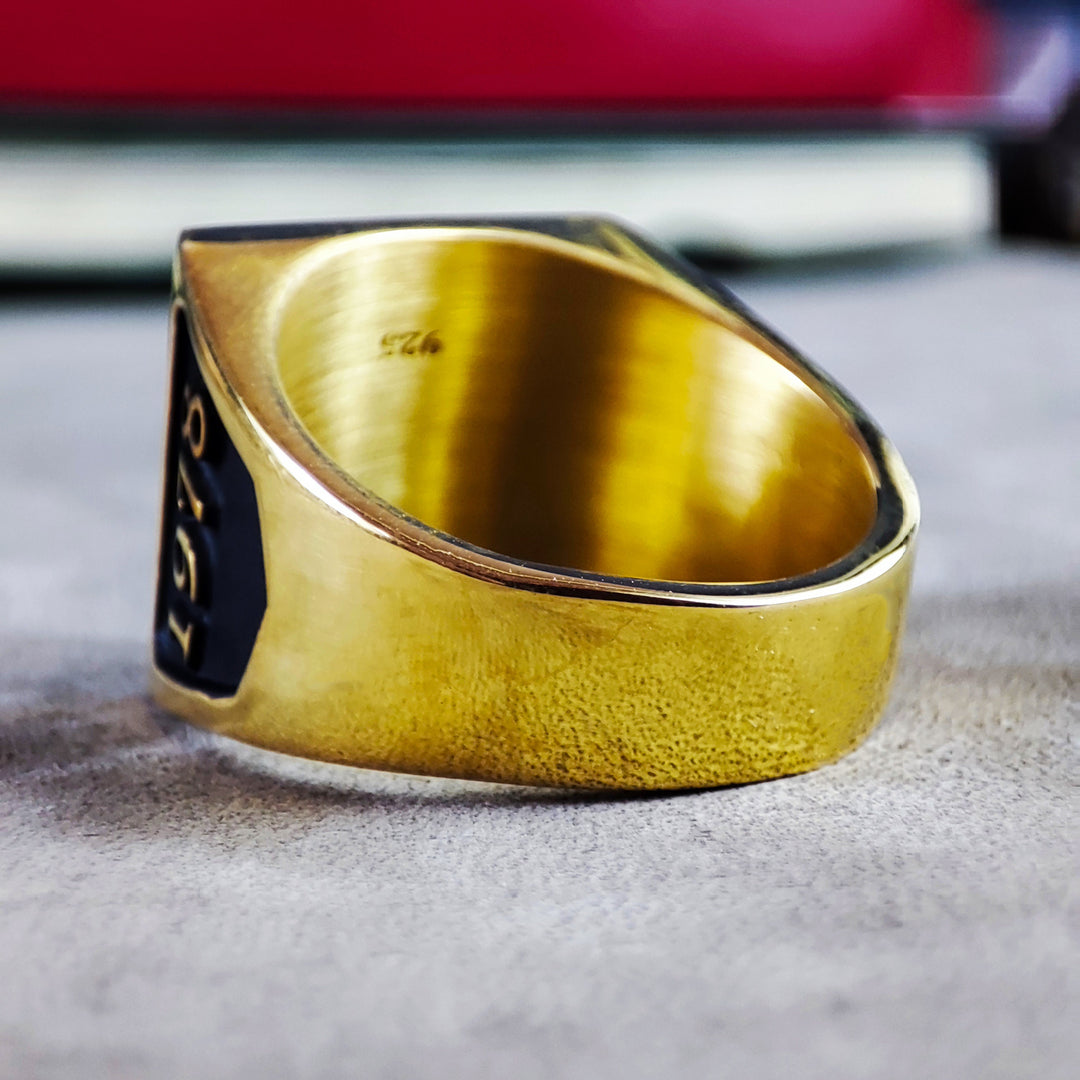 A handcrafted gold-plated signet ring showcasing an enameled family crest with intricate engraving. The square shape gives it a powerful presence, making it a striking statement piece for men. Perfect for those with a passion for history and personal heritage, this heirloom-quality crest ring is designed for both elegance and longevity.