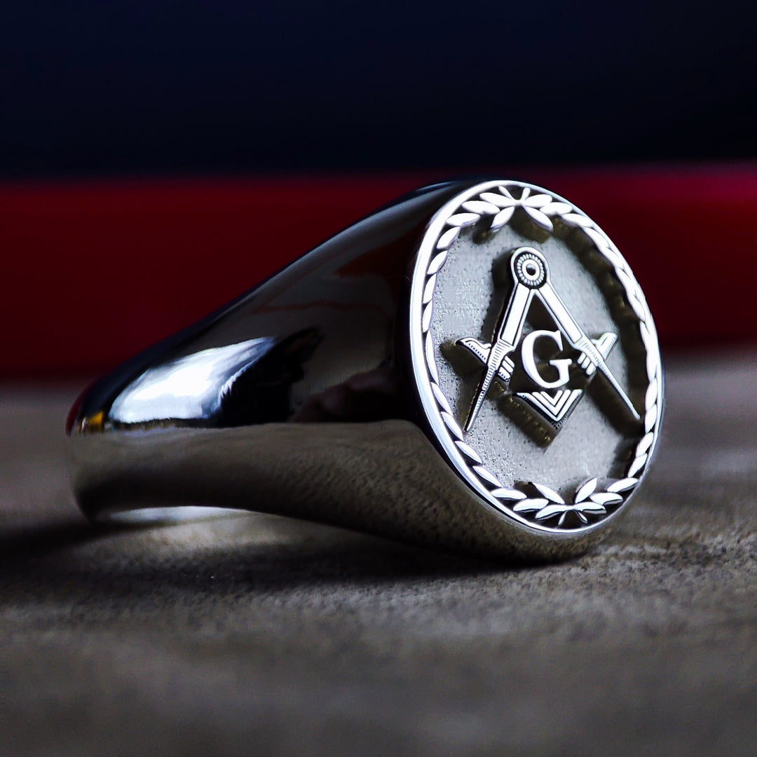 A distinguished Masonic signet ring, handcrafted in sterling silver with an intricate leaf pattern surrounding the Freemason emblem. This ring represents brotherhood, tradition, and knowledge. Designed for men who appreciate heritage and symbolism, this unique lodge jewelry piece makes a thoughtful gift for fellow Freemasons or an heirloom-worthy accessory.