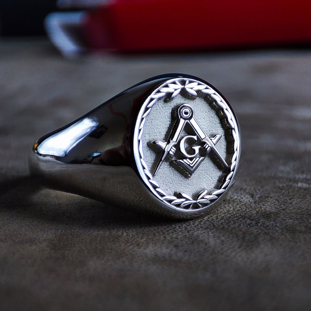 Designed for Freemasons, this sterling silver signet ring combines intricate craftsmanship with Masonic tradition. The engraved leaf pattern complements the bold square and compass emblem, making it a refined and symbolic lodge ring. Perfect for formal meetings, Masonic rituals, or as a unique statement accessory.