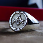 Load image into Gallery viewer, This silver Masonic ring features a detailed engraved leaf pattern, symbolizing growth and wisdom. Designed for Freemasons, this signet ring carries the iconic square and compass emblem, representing fraternity and enlightenment. Crafted in sterling silver, this elegant lodge ring is a perfect addition to any Masonic collection, making it a meaningful and symbolic piece for members and collectors alike.