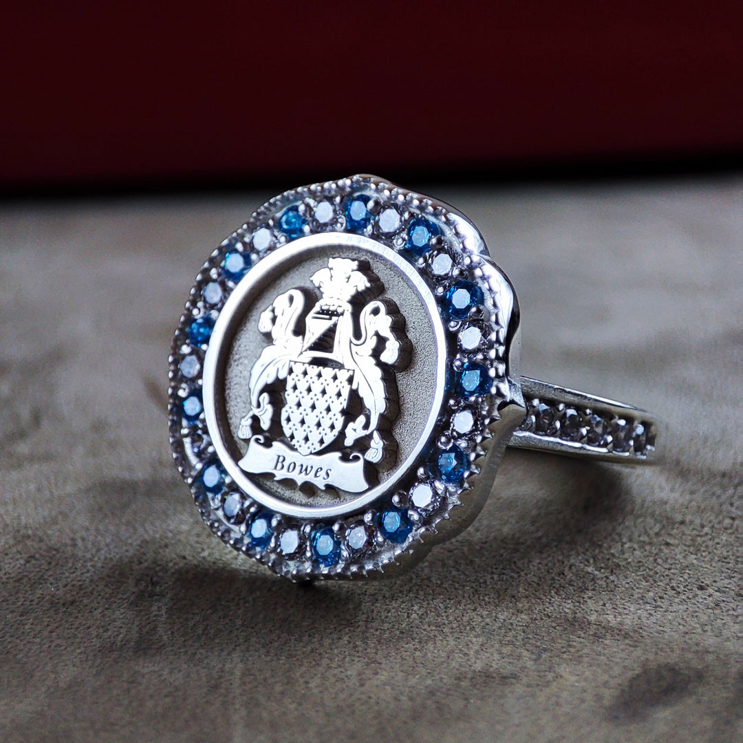 Gold family crest ring with an engraved coat of arms and a custom-set stone. This personalized ring makes a wonderful gift for women who value family connections and heritage.