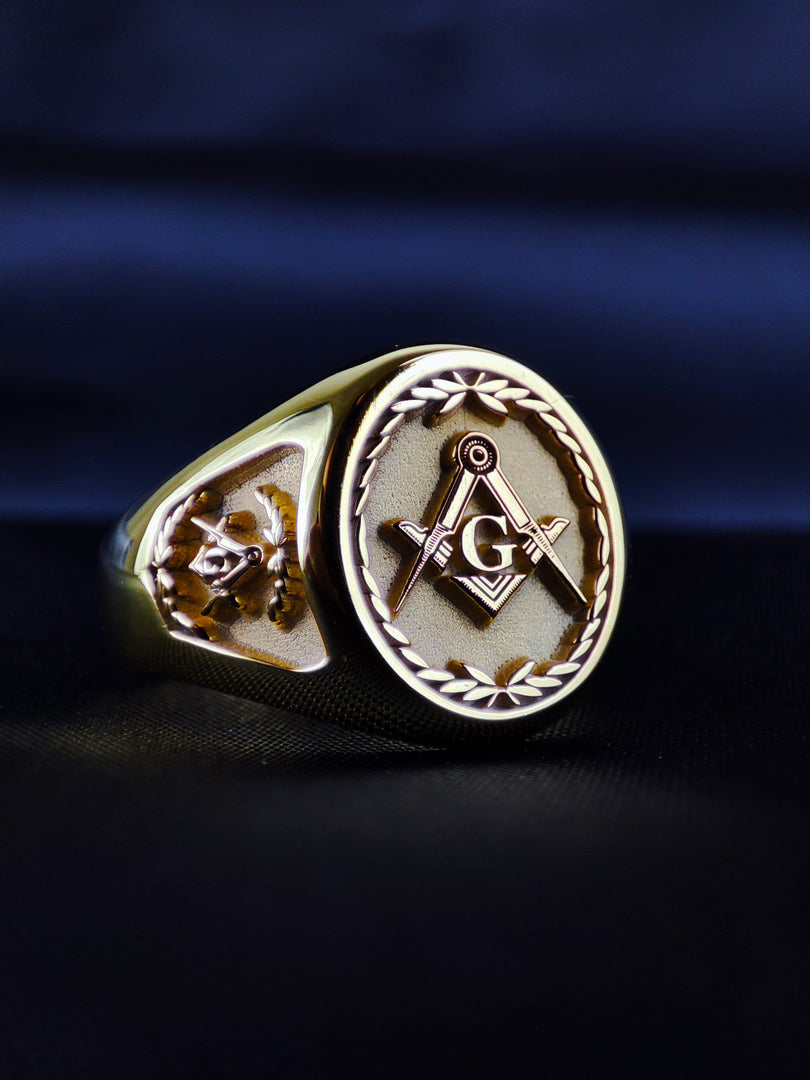 Custom Masonic ring in gold plated finish with personalized engraving options including initials or lodge number. The ornate band design and central emblem reflect tradition and brotherhood. This bold men's ring is ideal for everyday wear or Masonic events. Handcrafted with precision, it’s a perfect way to honor your journey. A meaningful piece that combines symbolism, identity, and refined design in gold.