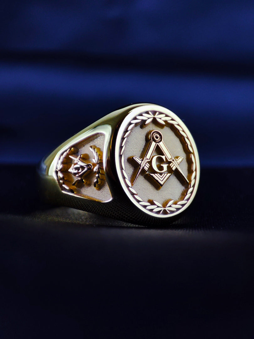 Elegant and symbolic, this gold plated Freemason ring showcases detailed engraving, custom personalization, and a bold patterned band. The centerpiece features the square and compass symbol, framed by ornate designs. Whether worn for ceremonies, daily expression, or gifted to a brother, this ring captures the strength of Masonic identity in a refined, timeless piece. Make it personal with your initials or meaningful dates.