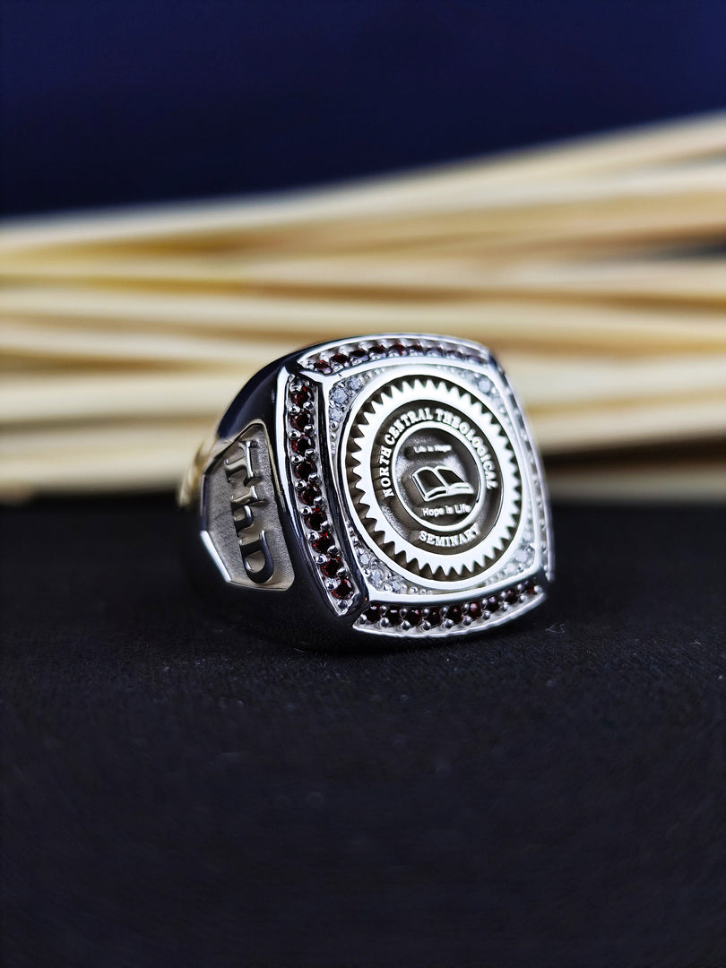 Personalized graduation ring for men, featuring a stone and college crest. Available in gold plating, this ring is a unique way to celebrate academic milestones.