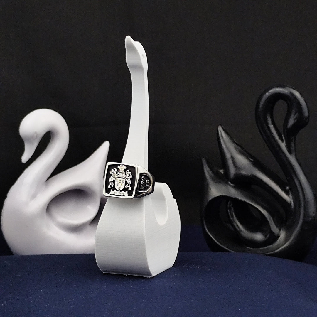 Designed for those who value history and nobility, this square heraldic family crest ring is a statement of elegance. Crafted from sterling silver and finished with black enamel, it showcases a custom coat of arms engraving. A perfect choice for those looking for a unique heirloom or commemorative jewelry piece, ideal for gifting on special occasions.