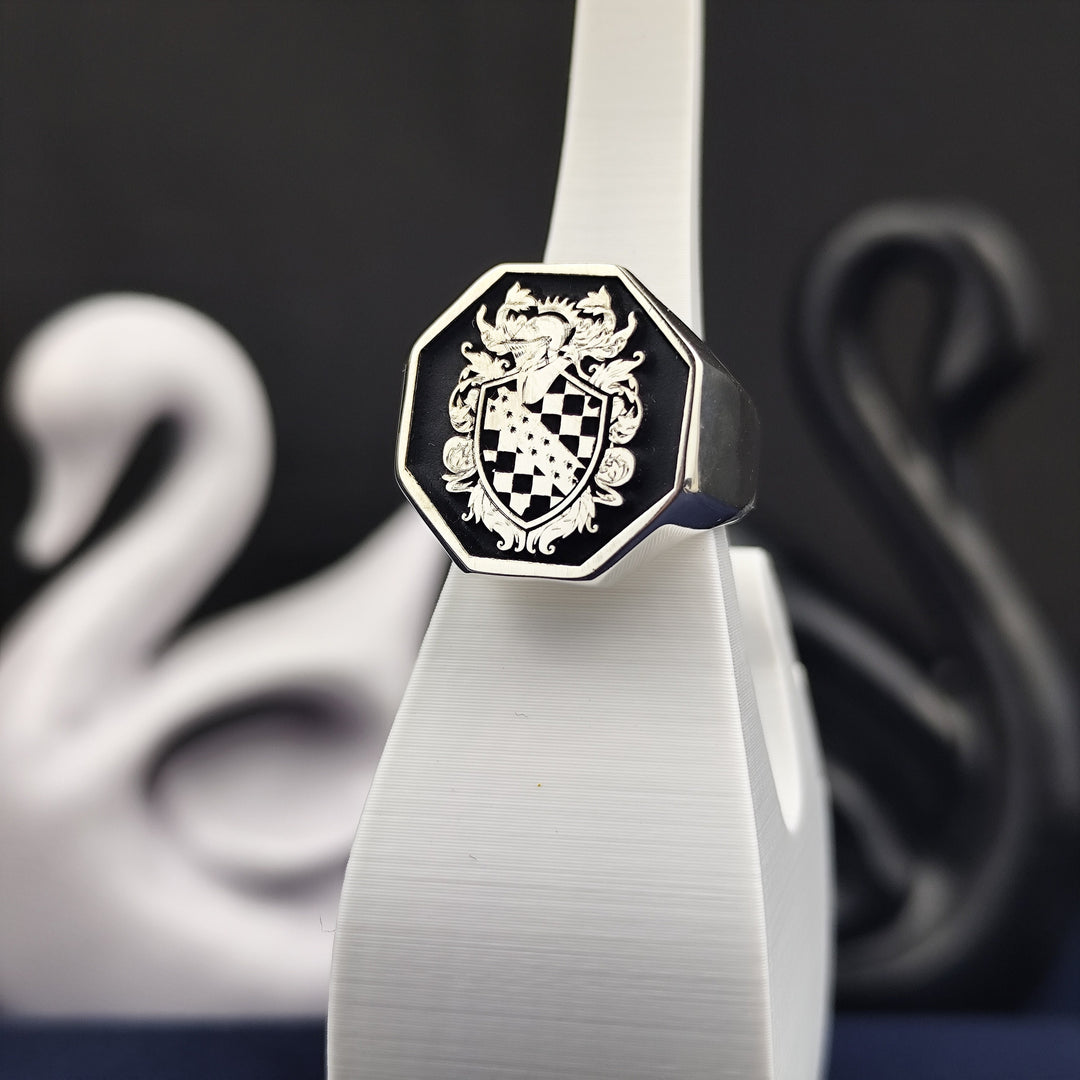 This octagon-shaped family crest ring is crafted in high-quality silver with an intricate engraved coat of arms. The recessed design is enhanced with black enamel, creating a striking contrast that highlights the fine details. A unique and noble heirloom piece, this heraldic signet ring is perfect for those who value tradition, making it a meaningful gift for history enthusiasts and collectors.