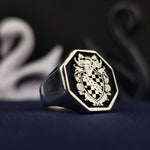 Load image into Gallery viewer, Honor your family legacy with this custom octagonal signet ring, featuring a deeply engraved crest with black enamel accents. The silver finish ensures durability and elegance, making it a unique heirloom jewelry piece. A refined statement accessory for those who embrace heritage, ideal as a meaningful keepsake or gift.