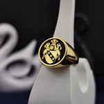 Load image into Gallery viewer, Honor your heritage with this gold-plated round signet ring, engraved with a customized coat of arms. A distinguished and meaningful jewelry piece, it serves as a lasting tribute to family legacy. Whether for daily wear or ceremonial occasions, this family crest ring makes a unique and personal statement, symbolizing strength, history, and tradition in an elegant way.