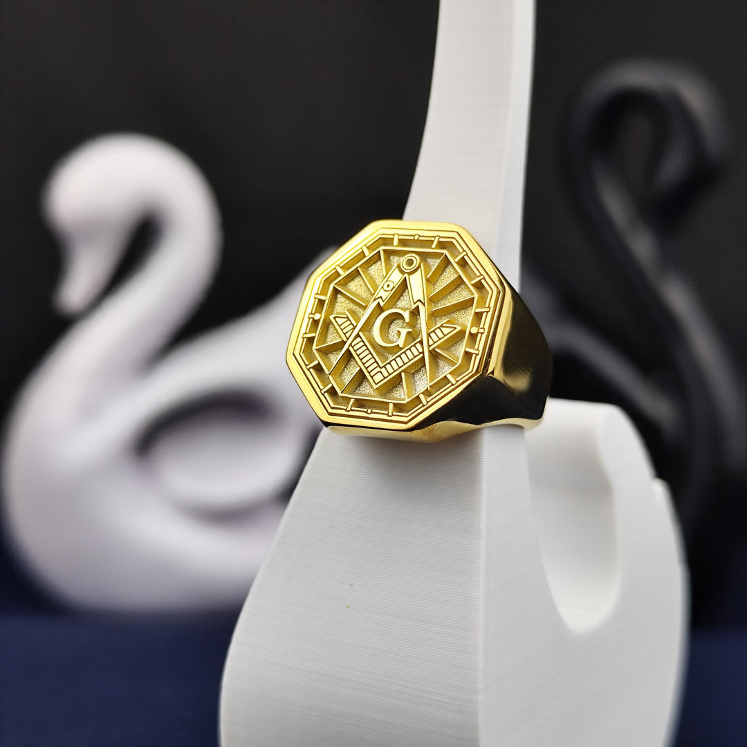 This antique-inspired gold-plated Masonic ring features an octagonal face with an intricate engraved emblem of the square and compass. A true symbol of fraternity and enlightenment, this signet ring is a meaningful keepsake for Freemasons. A timeless piece of jewelry that carries deep significance, perfect for gifting or personal wear.