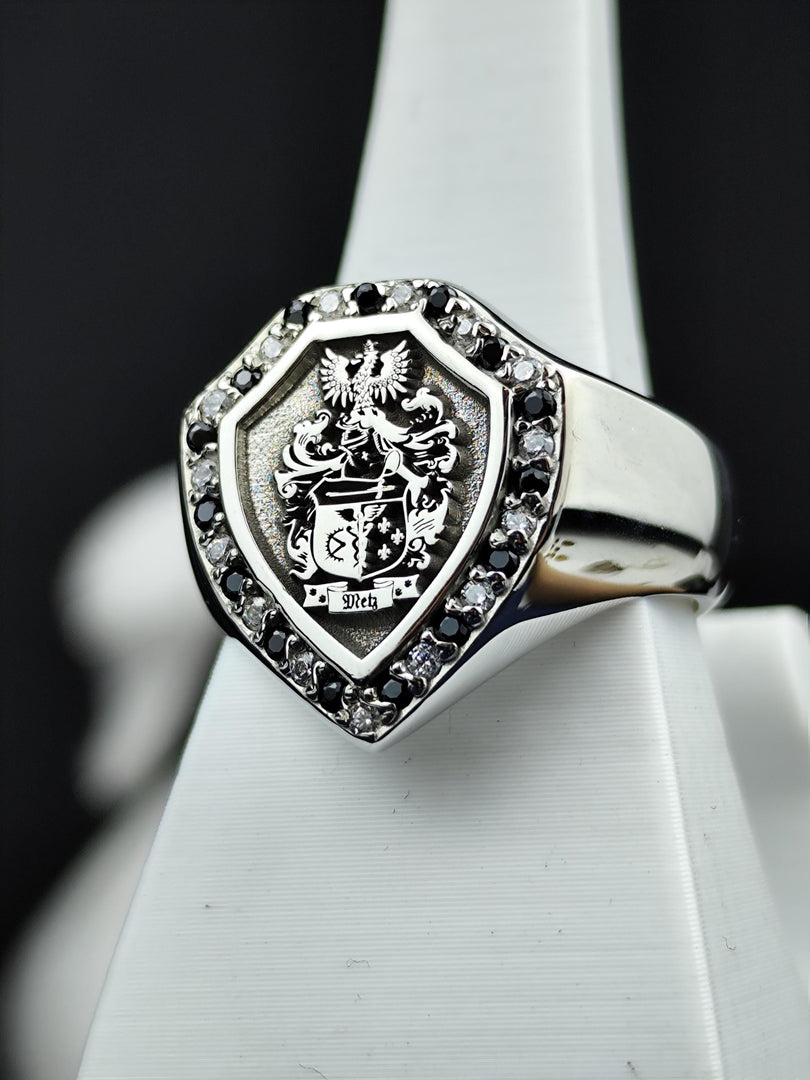 Celebrate your ancestry with this exquisite shield signet ring, engraved with a detailed family crest and adorned with black and white stones. A timeless and meaningful jewelry piece, this coat of arms ring represents noble lineage and personal pride. A striking heirloom for collectors or individuals who appreciate heritage-inspired jewelry.