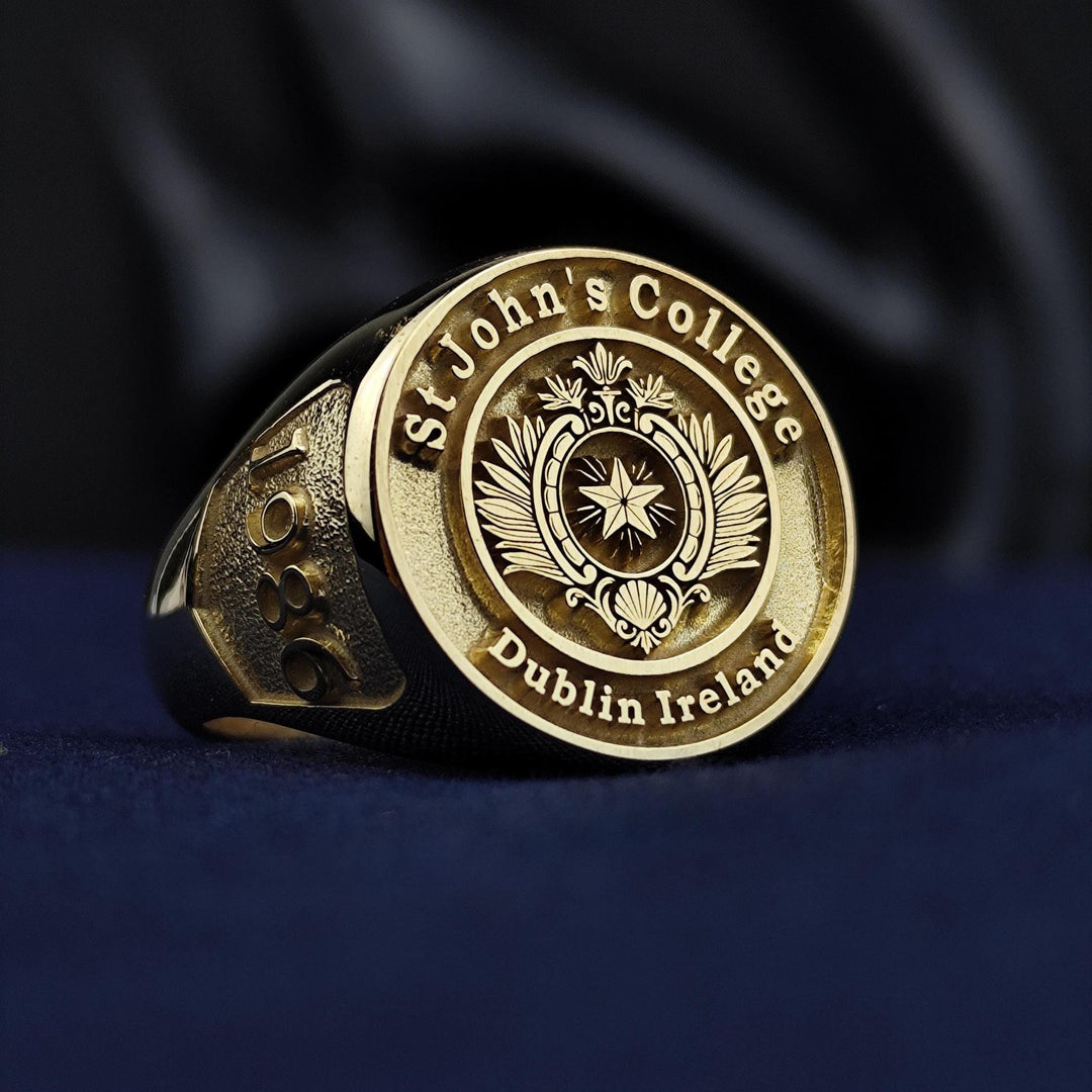 University ring in gold plating, personalized with a detailed crest. A timeless keepsake for graduates and proud alumni.