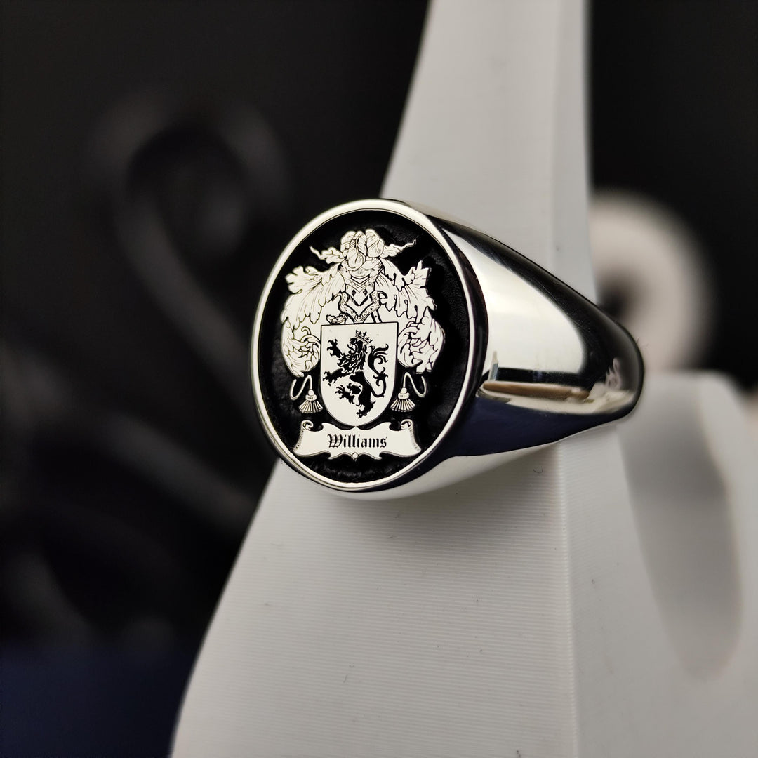A bold and elegant round heraldic ring, designed in sterling silver with a custom coat of arms engraving and black enamel detailing. This unique family crest ring is a sophisticated heirloom that symbolizes history and tradition. A perfect gift for those who wish to honor their family name with a timeless and personalized piece of jewelry.