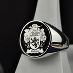 Load image into Gallery viewer, A refined round signet ring, crafted in sterling silver with a personalized family crest engraving and black enamel finish. This noble and sophisticated piece is perfect for those who cherish their heritage. Whether passed down as a family heirloom or worn as a daily emblem of history and pride, this custom coat of arms ring is a striking tribute to tradition and legacy.