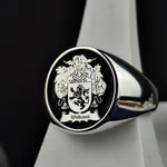 Load image into Gallery viewer, A refined round signet ring, crafted in sterling silver with a personalized family crest engraving and black enamel finish. This noble and sophisticated piece is perfect for those who cherish their heritage. Whether passed down as a family heirloom or worn as a daily emblem of history and pride, this custom coat of arms ring is a striking tribute to tradition and legacy.