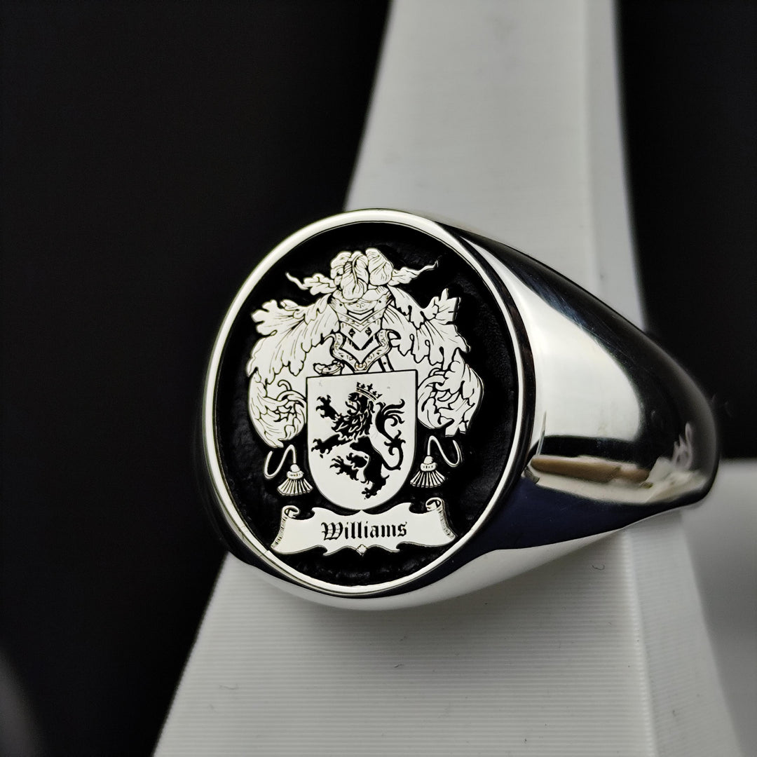 A refined round signet ring, crafted in sterling silver with a personalized family crest engraving and black enamel finish. This noble and sophisticated piece is perfect for those who cherish their heritage. Whether passed down as a family heirloom or worn as a daily emblem of history and pride, this custom coat of arms ring is a striking tribute to tradition and legacy.