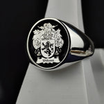 Load image into Gallery viewer, This vintage-style silver signet ring features a round face engraved with a family crest, accentuated with black enamel for a striking effect. A timeless symbol of noble heritage, this custom coat of arms ring is designed for those who appreciate historical significance and fine craftsmanship. A refined and meaningful addition to any jewelry collection.