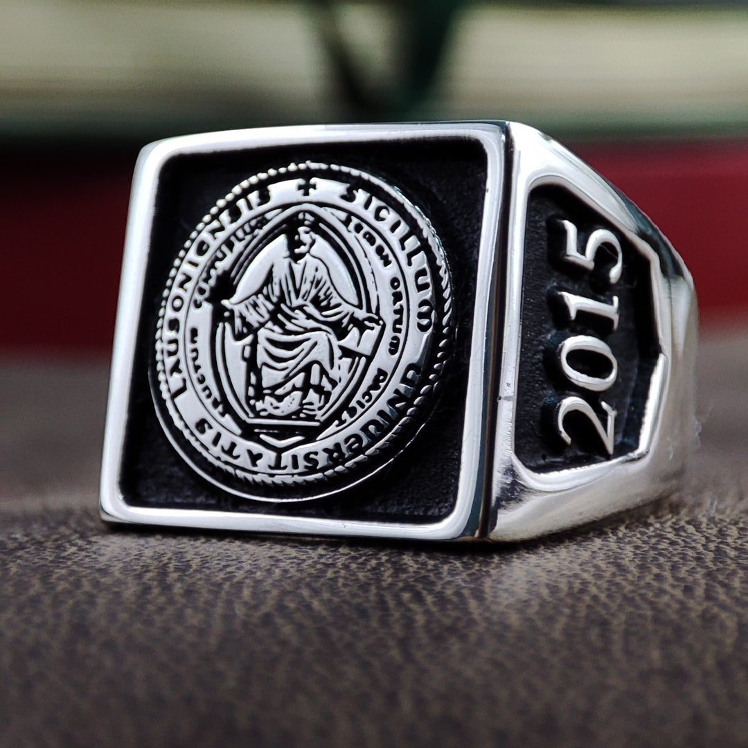 This men&#39;s silver university ring is a bold statement piece, featuring a square design with custom engravings. Whether for a graduate, student, or alumni, this ring is a meaningful symbol of dedication and hard work. The polished silver finish enhances its elegance, making it a refined and timeless piece of academic jewelry. Ideal for celebrating milestones, it is a perfect graduation gift.