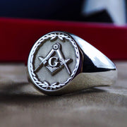 This silver Masonic ring features a detailed engraved leaf pattern, symbolizing growth and wisdom. Designed for Freemasons, this signet ring carries the iconic square and compass emblem, representing fraternity and enlightenment. Crafted in sterling silver, this elegant lodge ring is a perfect addition to any Masonic collection, making it a meaningful and symbolic piece for members and collectors alike.