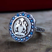 Women’s coat of arms ring with a set stone, crafted in gold and featuring a detailed family crest. This personalized ring celebrates heritage and is perfect as a meaningful heirloom.