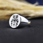 Load image into Gallery viewer, A striking round signet ring featuring a recessed engraving of a family crest, designed for men who value heritage and ancestry. This heirloom-quality ring is a perfect blend of tradition and modern craftsmanship, making it a meaningful gift for special occasions. Crafted with precision and durability, it serves as a lifelong symbol of family pride.
