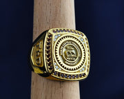 Custom men’s university ring with gold plating and a stone setting. This ring symbolizes academic pride and is perfect for alumni and recent graduates alike.