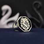 Load image into Gallery viewer, This custom octagon signet ring showcases a deeply engraved family crest, enhanced by black enamel for a sophisticated look. Made in sterling silver, it combines historical elegance with modern craftsmanship. A noble and refined jewelry piece, perfect for celebrating ancestry and passing down as an heirloom for future generations.
