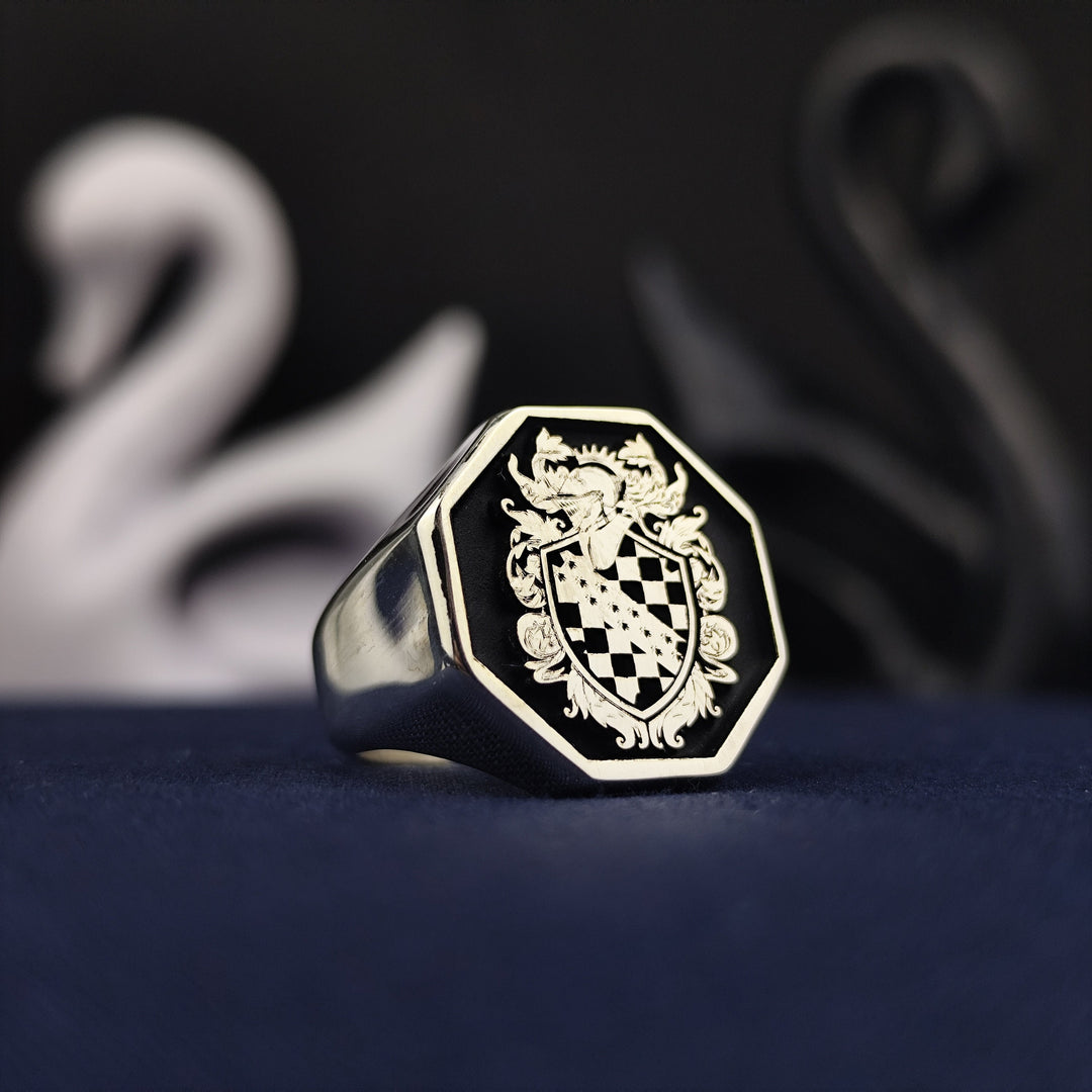 This custom octagon signet ring showcases a deeply engraved family crest, enhanced by black enamel for a sophisticated look. Made in sterling silver, it combines historical elegance with modern craftsmanship. A noble and refined jewelry piece, perfect for celebrating ancestry and passing down as an heirloom for future generations.