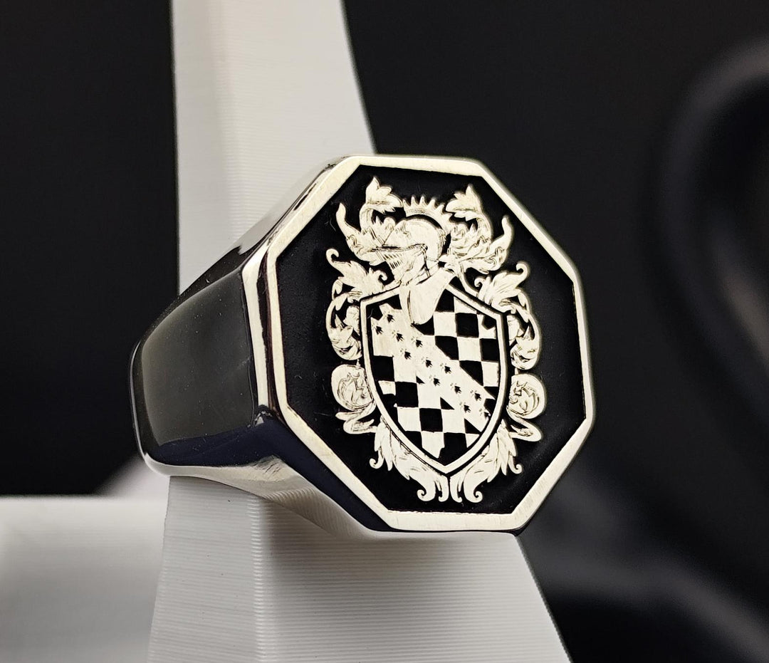 Designed for those who appreciate tradition, this silver octagonal signet ring features a custom coat of arms engraving. The bold geometric shape enhances its regal presence, making it a meaningful family heritage piece. Finished with black enamel to highlight the intricate details, this crest ring is an ideal heirloom for preserving noble lineage.