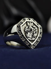 This shield-shaped family crest ring is a bold and elegant signet piece, featuring an engraved coat of arms with black and white stones. Crafted for those who appreciate heraldic symbolism, this custom jewelry piece is a meaningful heirloom. Designed with precision, it represents noble heritage, making it a perfect statement accessory for those who value tradition and legacy.