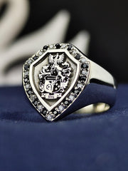 This noble shield-shaped signet ring is custom-engraved with a family crest and set with contrasting black and white stones. Designed for those who cherish history and heritage, this heraldic ring serves as a sophisticated heirloom. Whether gifted for a milestone occasion or worn as a personal emblem, this unique jewelry piece captures the essence of nobility.