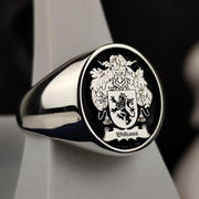 This round silver family crest ring is a distinguished piece of heraldic jewelry, featuring a deeply engraved coat of arms with black enamel detailing. Designed for those who value heritage, this signet ring is a timeless heirloom. Whether worn as a symbol of lineage or given as a meaningful gift, this custom crest ring blends historical tradition with modern craftsmanship, making it a bold statement accessory.