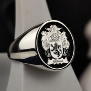 This round silver family crest ring is a distinguished piece of heraldic jewelry, featuring a deeply engraved coat of arms with black enamel detailing. Designed for those who value heritage, this signet ring is a timeless heirloom. Whether worn as a symbol of lineage or given as a meaningful gift, this custom crest ring blends historical tradition with modern craftsmanship, making it a bold statement accessory.